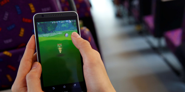 A passenger plays the augmented reality mobile game "Pokemon Go" by Nintendo inside a bus in Hong Kong, China August 12, 2016. REUTERS/Tyrone Siu