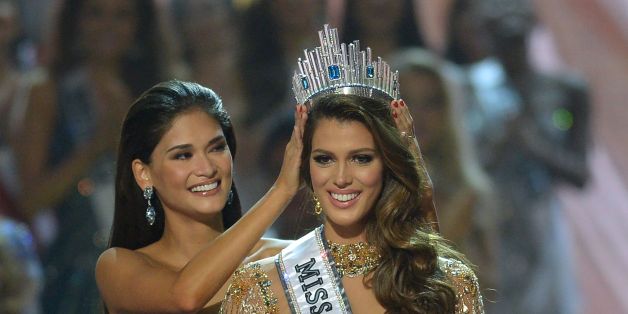 Miss Universe contestant Iris Mittenaere (R) of France is crowned the new 2017 winner by former Miss Universe Pia Wurtzbach of the Philippines (L) during the Miss Universe pageant at the Mall of Asia Arena in Manila on January 30, 2017.France was crowed Miss Universe on January 30 in a glitzy spectacle free of last year's dramatic mix-up but with a dash of political controversy as finalists touched on migration and other hot-button global issues. / AFP / TED ALJIBE (Photo credit should re