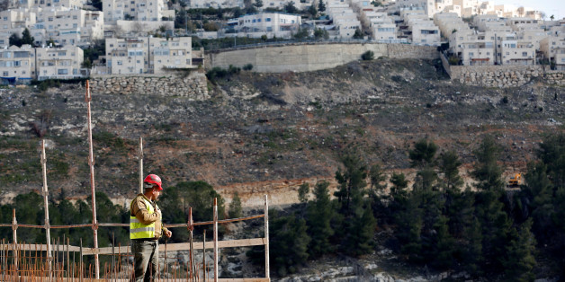 A labourer works at a construction site in the Israeli settlement of Ramot, as the Israeli settlement of Ramat Shlomo is seen in the background, in an area of the occupied West Bank that Israel annexed to Jerusalem January 22, 2017. REUTERS/Ronen Zvulun