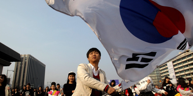 SEOUL, SOUTH KOREA - FEBRUARY 22: A South Korean student waves national flags during an anti-Japan rally on February 22, 2014 in Seoul, South Korea. South Korea and Japan are making claim to a set of islands controlled by South Korea, Dokdo or Takeshima, located in the East Sea. The rally was taking place after the Japanese government declared today to be Takeshima Day, further fueling a long-standing territorial row between the two countries. (Photo by Chung Sung-Jun/Getty Images)