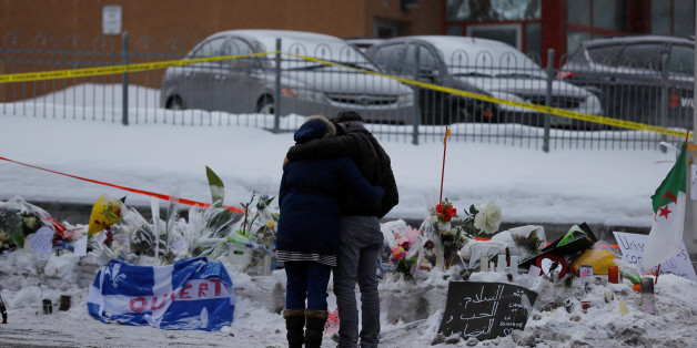 Azzedine Najd (R) and his wife Fadwa Achmaoui look at the memorial near the site of a fatal shooting at the Quebec Islamic Cultural Centre in Quebec City, Canada January 31, 2017. REUTERS/Mathieu Belanger