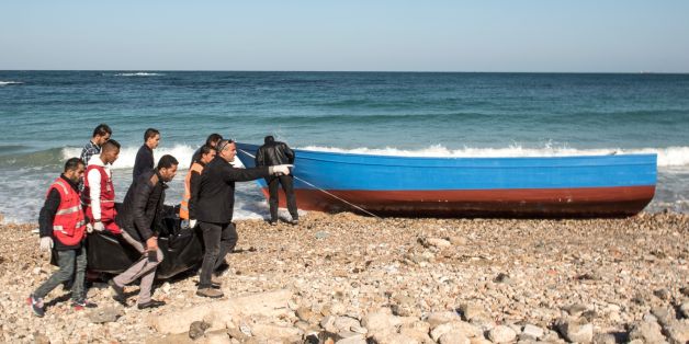Members of the Libyan Red Crescent carry the bodies of drowned immigrants after they washed ashore in the Andalus district of the capital Tripoli, on January 4, 2017.After several days at sea 80 mostly Senegalese migrants who left Sabratha on a boat spotted land, thinking it was Italy. Several drowned trying to swim to shore. But when the survivors reached dry land they found they were still in Libya. / AFP / TAHA JAWASHI (Photo credit should read TAHA JAWASHI/AFP/Getty Images)