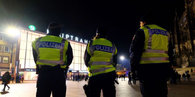 Policemen walk around the Cologne cathedral and main train station on December 31, 2016 during the New Year's eve. / AFP / PATRIK STOLLARZ (Photo credit should read PATRIK STOLLARZ/AFP/Getty Images)