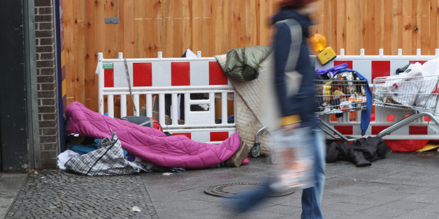 Mann geht an einem Obdachlosen in Berlin vorbei