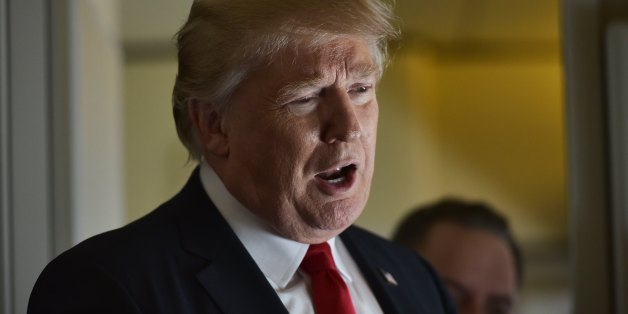 US President Donald Trump chats with reporters on board Air Force One before departing from Andrews Air Force Base in Maryland, bound for Palm Beach, Florida on February 3, 2017. / AFP / Mandel Ngan (Photo credit should read MANDEL NGAN/AFP/Getty Images)