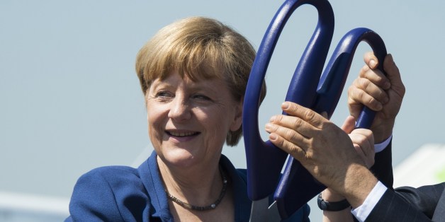 German Chancellor Angela Merkel holds scissors during the opening ceremony of the International Air Show ILA in Schoenefeld near Berlin on May 20, 2014. Turkey is partner country of this year's aerospace trade show that runs until May 25, 2014. AFP PHOTO / JOHANNES EISELE (Photo credit should read JOHANNES EISELE/AFP/Getty Images)