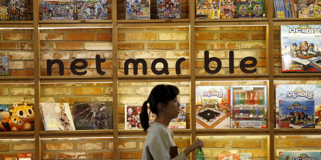 An employee walks past the logo of Netmarble Games at its headquarters in Seoul, South Korea, March 25, 2016. Amid a resurgence in Seoul's IPO interest, newer firms are also set to pile in, including top mobile game maker Netmarble Games with a projected $1.7 billion listing. REUTERS/Kim Hong-Ji