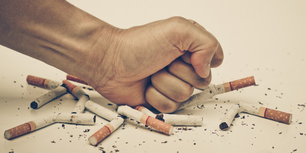 male hand destroying cigartees - stop smoking concept