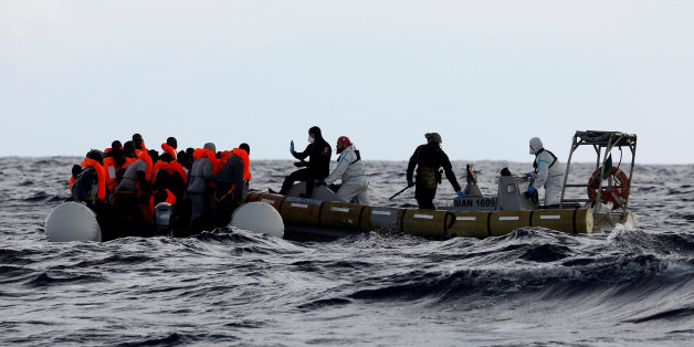 Italian Navy personnel rescues migrants from their overcrowded raft, as lifeguards from the Spanish NGO Proactiva Open Arms rescue all 112 on aboard, including two pregnant women and five children, as it drifts out of control in the central Mediterranean Sea, some 36 nautical miles off the Libyan coast January 2, 2017. REUTERS/Yannis Behrakis
