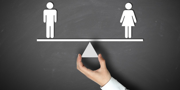 Male equals female concept with businessman hand holding against blackboard background.