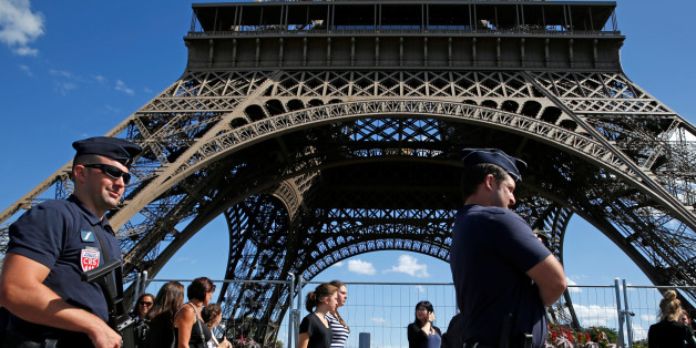 French CRS policemen patrol as tourists walk past in front of the Eiffel Tower in Paris, France August 20, 2016. REUTERS/Pascal Rossignol