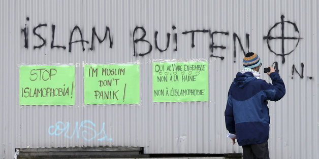 Pasted signs reading "Stop Islamophobia" and "I'm Muslim don't panic" are seen under an anti-Islam grafitti during a protest against Islamophobia in front of the Brussels' Justice Palace October 26, 2014. REUTERS/Francois Lenoir (BELGIUM - Tags: CIVIL UNREST RELIGION)