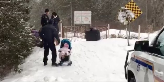 An Kanadas Grenze helfen zwei Beamte einer syrischen Flüchtlingsfamilie.