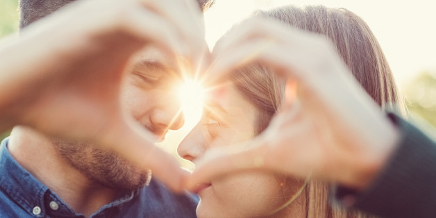 Young people showing a heart-shaped symbol with hands