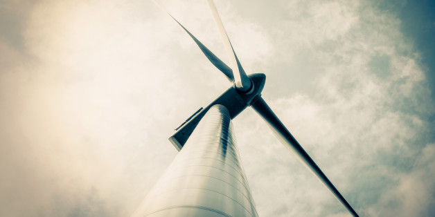 Windmill against blue sky with white clouds into the sun