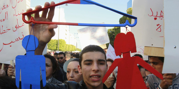 A protester holds a makeshift sign representing men and women during a protest in Tunis January 29, 2011. The protesters are calling for equality between men and women. REUTERS/Louafi Larbi (TUNISIA - Tags: POLITICS CIVIL UNREST SOCIETY)