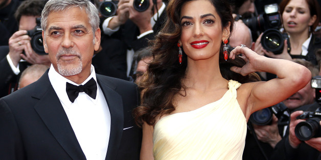 Cast member George Clooney and his wife Amal pose on the red carpet as they arrive for the screening of the film "Money Monster" out of competition during the 69th Cannes Film Festival in Cannes, France, May 12, 2016. REUTERS/Eric Gaillard