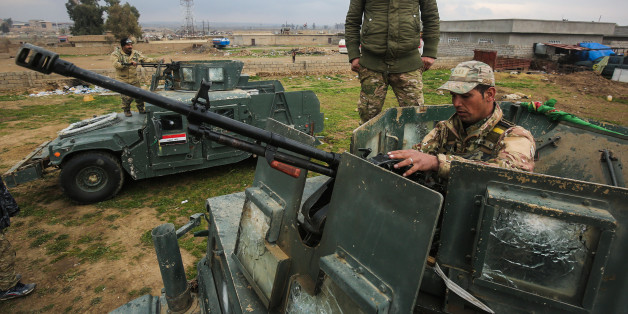 A member of the Iraqi forces loads a machine gun belt atop an armoured vehicle as he prepares his combat gear in Oreij village, south of Mosul, on February 15, 2017. / AFP / AHMAD AL-RUBAYE (Photo credit should read AHMAD AL-RUBAYE/AFP/Getty Images)