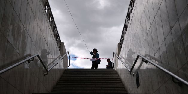 A woman reads an announcement informing about a 48-hours strike as she stands at a closed metro station in Athens, on May 6, 2016. Greece's labour unions stage a two-day general strike to protest against controversial government plans to overhaul pensions and increase taxes to meet demands of its bailout creditors. / AFP / LOUISA GOULIAMAKI (Photo credit should read LOUISA GOULIAMAKI/AFP/Getty Images)