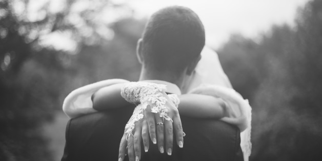 The bride put her hands on the shoulders of the groom. They are kissing.