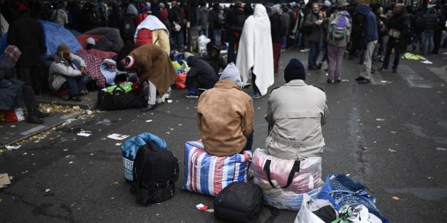 Migrant wait during the evacuation of a makeshift camp near Stalingrad metro station in Paris on November 4, 2016, one of several camps sprouting up around the French capital. Over 2000 migrants were moved by police from the Paris town center to a legal migrant camp. / AFP / LIONEL BONAVENTURE (Photo credit should read LIONEL BONAVENTURE/AFP/Getty Images)