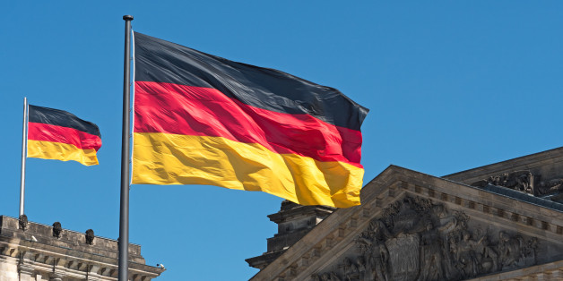 two Germany flags on top of the Reichstag