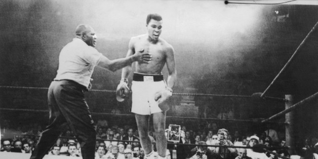 Photo prise le 26 mai 1965 à Lewiston, aux Etats-Unis, lors du championnat du monde de boxe des poids lourds au cours duquel le boxeur américain Mohamed Ali (Cassius Clay) (C) a conservé son titre de champion de monde en battant Sonny Liston (au sol) par K.O au premier round après une minute d'un combat arbitré par Joe Walcott (G).A picture taken May 26, 1965, in Lewiston, USA, during the world heavyweight boxing championship, at the end of which the American Muhammad Ali (Cassius