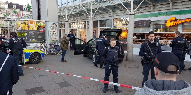 Policemen stand around a car in front of a business building in Heidelberg, western Germany, where a man ploughed into pedestrians on February 25, 2017. / AFP / dpa / R. PRIEBE / Germany OUT (Photo credit should read R. PRIEBE/AFP/Getty Images)