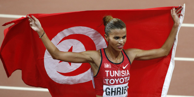 Habiba Ghribi of Tunisia holds her national flag after finishing second in the women's 3000 metres steeplechase final at the IAAF World Championships at the National Stadium in Beijing, China August 26, 2015. REUTERS/Kim Kyung-Hoon