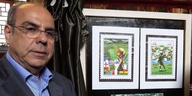 President of the Algerian Football Federation (FAF) Mohamed Raouraoua poses for a picture near new released stamps displayed at the 'Grande Poste' in Algiers, on May 5, 2010. Algerian post authorities released a new range of stamps represnting the National football team that taking place in the World Cup 2010 in South Africa. AFP PHOTO / STR (Photo credit should read STR/AFP/Getty Images)