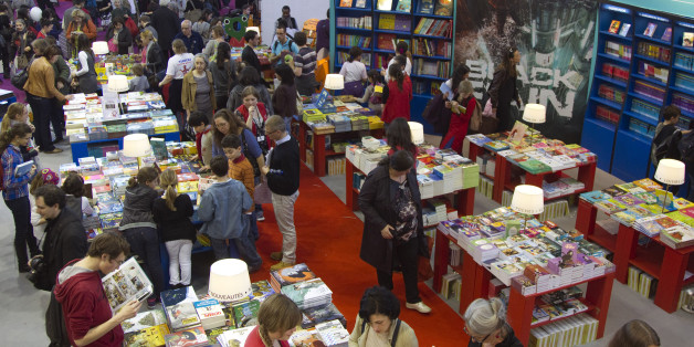 Visitors to the Paris Book Fair look at children's books on display on the opening day of the four-day event in Paris, March 16, 2012. REUTERS/Charles Platiau (FRANCE - Tags: SOCIETY)