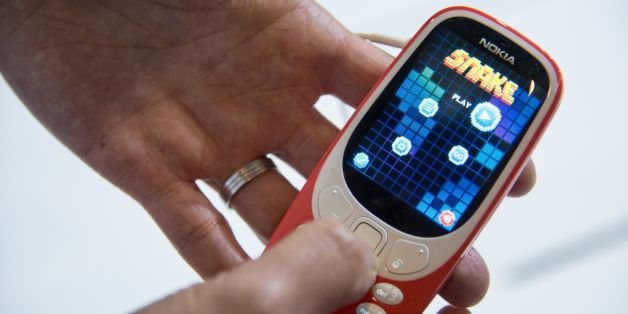 A person plays 'Snake' game on the new 'Nokia 3310' model of Finnish HMD global on the first day of the Mobile World Congress in Barcelonaon on February 27, 2017 in Barcelona.
Phone makers will seek to seduce new buyers with artificial intelligence functions and other innovations at the world's biggest mobile fair starting today in Spain.
/ AFP / Josep Lago (Photo credit should read JOSEP LAGO/AFP/Getty Images)