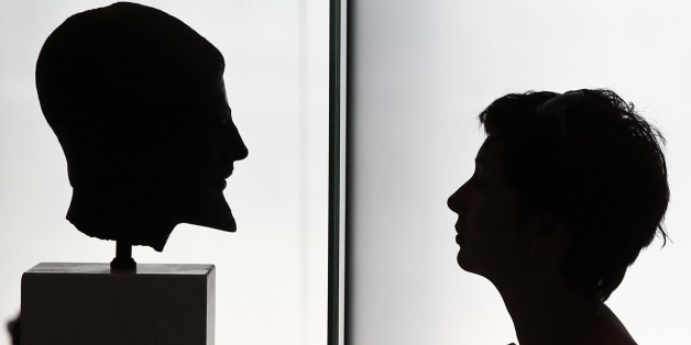 A visitor looks at a head of a bronze statue depicting a bearded hoplite inside the Acropolis museum in Athens August 13, 2013. According to data from the country's statistics service ELSTAT, 19 percent more people visited Greece's museums and 35.4 percent more visited its archaeological sites in the first four months of the year compared to 2012. REUTERS/Yorgos Karahalis (GREECE - Tags: BUSINESS TRAVEL SOCIETY)