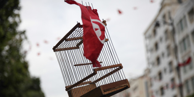 TUNIS, TUNISIA â JANUARY 14: An empty cage of bird decorated with a Tunisian flag is seen raised during a march held on avenue Habib Bourguiba in the capital Tunis, to celebrate Revolution Day, the six-year anniversary of the overthrow of the 23-year dictator President Ben Ali. (Photo by Chedly Ben Ibrahim/Corbis via Getty Images)