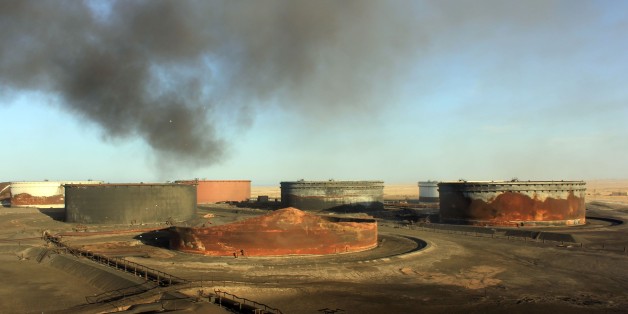 A picture taken on January 8, 2016 showssmoke billowing from a petroleum storage tank after a fire was extinguished at Al-Sidra oil terminal, near Ras Lanuf in the so-called 'oil crescent' along Libya's northern coast. At least four petroleum storage tanks were set ablaze during deadly fighting as the Islamic State group tries to seize coastal export terminals in eastern Libya, the National Oil Company said. / AFP / STRINGER (Photo credit should read STRINGER/AFP/Getty Images)