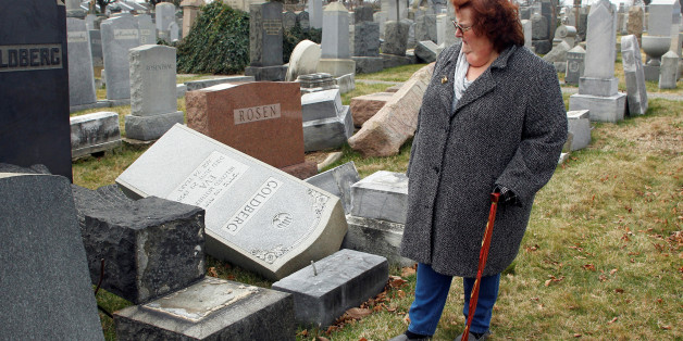 Judy Pogachefsky looks at headstones pushed off their bases by vandals in the Mount Carmel Cemetery, a Jewish cemetery, in Philadelphia, Pennsylvania, U.S. February 27, 2017. Pogachefsky's grandparents are buried in the cemetery and she was trying to locate their grave. REUTERS/Tom Mihalek