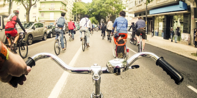 A group of bicycle riders taking the streets during a collective ride promoting the use of bicycles as a mode of transportation in the city of Lisbon.