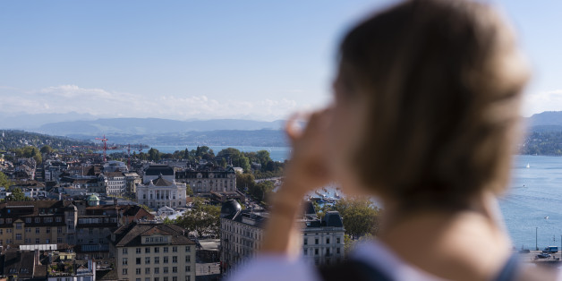 Zurich, Switzerland - 30 September 2016: A female tourist is taking pictures of Zurich from the observation deck on top of Grossmunster cathedral.