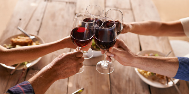 Shot of people toasting with wine over a meal