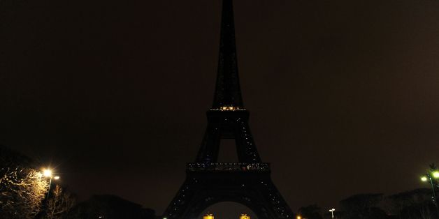 A person dressed as a WWF panda stands near the Eiffel Tower in Paris after it went dark for the Earth Hour environmental campaign on March 19, 2016. / AFP / THOMAS OLIVA (Photo credit should read THOMAS OLIVA/AFP/Getty Images)