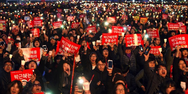 South Korean demonstrators hold up candles during a candlelit rally demanding arrest of Park Geun-Hye in Seoul on March 11, 2017.
South Korea's ousted leader Park Geun-Hye was holed up in the presidential Blue House Saturday as protesters took to Seoul's streets demanding her arrest, a day after a court upheld her impeachment. / AFP PHOTO / JUNG Yeon-Je (Photo credit should read JUNG YEON-JE/AFP/Getty Images)