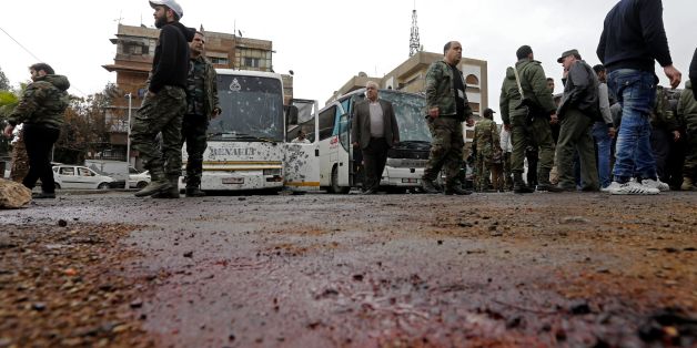 Syrian security forces and locals gather at the scene of a bombing following twin attacks targeting Shiite pilgrims in Damascus' Old City on March 11, 2017, in one of the bloodiest attacks in the Syrian capital.A roadside bomb detonated as a bus passed and a suicide bomber blew himself up in the Bab al-Saghir area, which houses several Shiite mausoleums that draw pilgrims from around the world, the Syrian Observatory for Human Rights said. / AFP PHOTO / Louai Beshara (Photo credit should