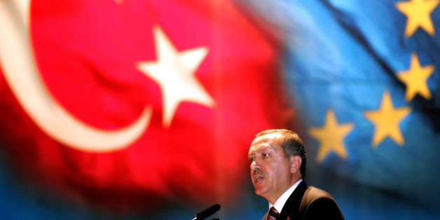 Turkey's Prime Minister Tayyip Erdogan makes a speech under Turkish and EU flags during a dinner "iftar", which ends the fasting for Muslims during Ramadan, in Istanbul where German Chancellor Gerhard Schroeder attended October 12, 2005. Schroeder arrived in Istanbul on Wednesday to attend an invitation by Erdogan following the October 3 decision on Turkey's accession talks into the EU. REUTERS/Fatih Saribas