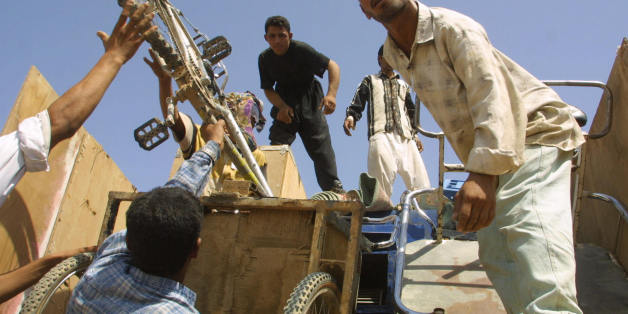 A group of 450 Iraqi refugees arrive in the southern Iraqi port city of Basra 23 September 2003 from Saudi Arabia, after spending 12 years in a desert camp in Rafha. The group had left for southern Iraq via Kuwait in a convoy of nine buses and nine trucks carrying their belongings yesterday. According to the UN refugee agency UNHCR, the group was the fourth to return home from Saudi Arabia. AFP/PHOTO/Ahmad Al-Rubaye (Photo credit should read AHMAD AL-RUBAYE/AFP/Getty Images)