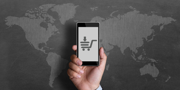Cropped image of a businessman showing online shopping of smart phone in front of world map.