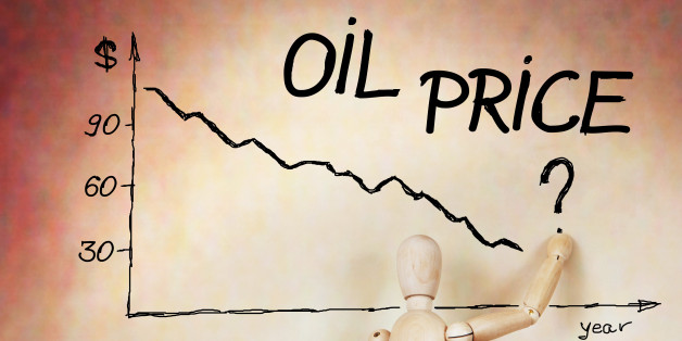 Businessman draws the graph of oil price fall. Abstract image with a wooden puppet