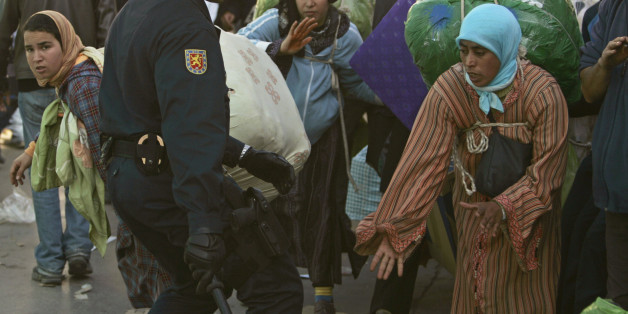 A Spanish policeman hits a Moroccan woman at the border between Spain and Morocco in Ceuta, January 31, 2008. Illegal migrants see Spain's enclaves in Morocco as gateways to a better life in Europe, but many Moroccans suffer beatings and pay bribes to go in past razor-wire fences just to be able to return home. Picture taken January 31, 2008. To match feature SPAIN-MOROCCO/SMUGGLING REUTERS/Rafael Marchante (SPAIN)