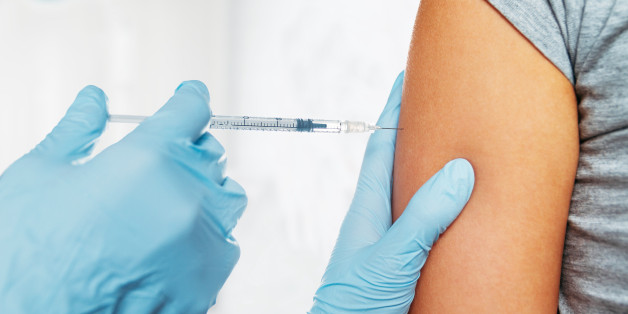 Nurse makes vaccination in the shoulder of patient in a clinic