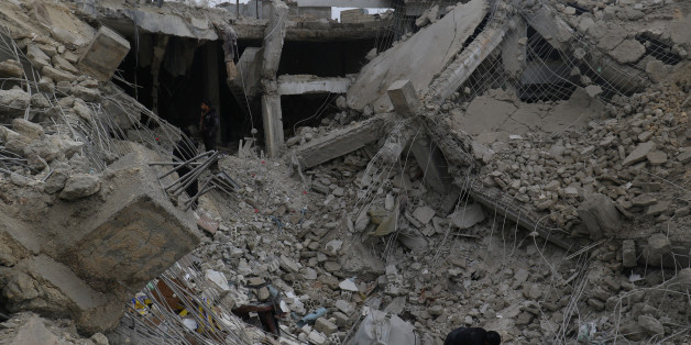 Men inspect damaged buildings after an airstrike on a market in rebel held Maarrat Misrin city in Idlib province, Syria January 14, 2017. REUTERS/Ammar Abdullah