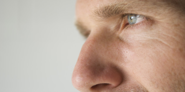 Close-up shot of a man's blue eye and prominent nose